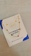Choker de perla y estrellas multicolor en cadena dorada sobre tarjeta de presentación