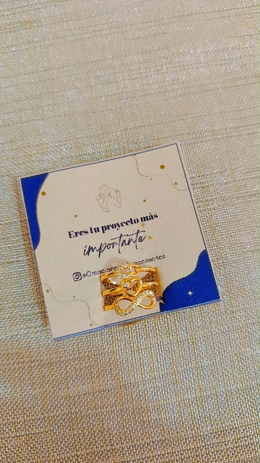 Anillo triple de corazón e infinito de rodio graduable sobre tarjeta de presentación