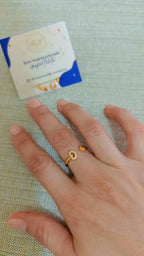 Anillo de rodio graduable con dije de corazón puesto en dedo