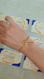 Pulsera de rodio con dije de corazón puesta en muñeca