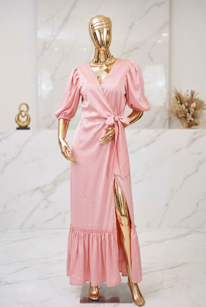 Vestido cruzado maxi rosado en maniquí dorado fondo mármol